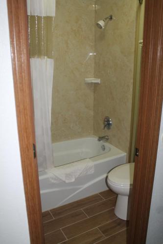 a bathroom with a toilet, tub, sink and shower at Columbus Inn in Columbus