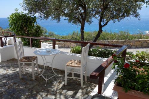 a table and chairs on a balcony with a view of the ocean at Cretan Village Hotel in Agios Nikolaos