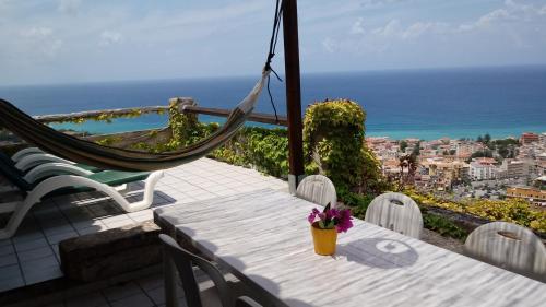 uma mesa e cadeiras numa varanda com vista para o oceano em Appartamenti Salato em Tropea