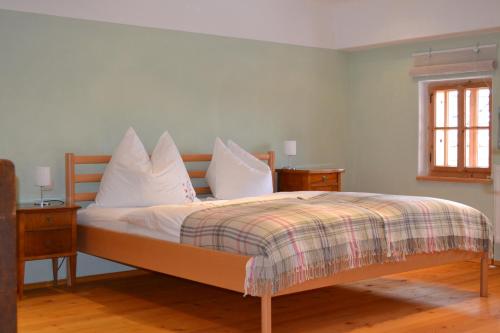een slaapkamer met een bed met witte lakens en kussens bij Bauernhof Kaspergut in Kirchberg bei Mattighofen
