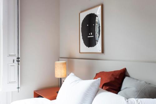 a bedroom with a bed and a table with a lamp at DestinationBCN - Universitat Rooms in Barcelona