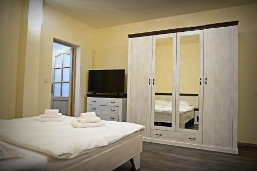 a bedroom with two beds and a tv and a dresser at Casa Remo - Guesthouse in Turda