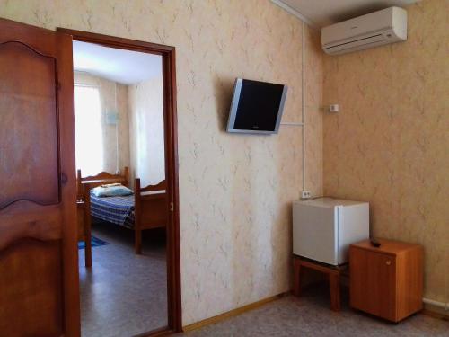 ベロレツクにあるHotel "Bankir"の冷蔵庫、壁掛けテレビが備わる客室です。