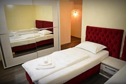 a bedroom with a red headboard and two beds at Casa Remo - Guesthouse in Turda