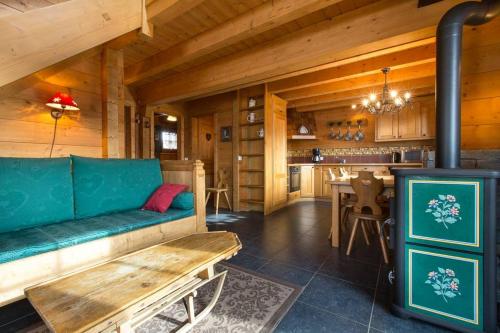 - un salon avec un canapé vert et une cuisinière dans l'établissement chalets-aravis, à La Clusaz