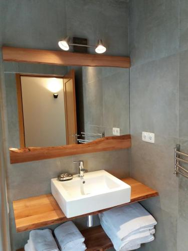 a bathroom with a sink and a mirror and towels at Villas Casteletes in Urzelina