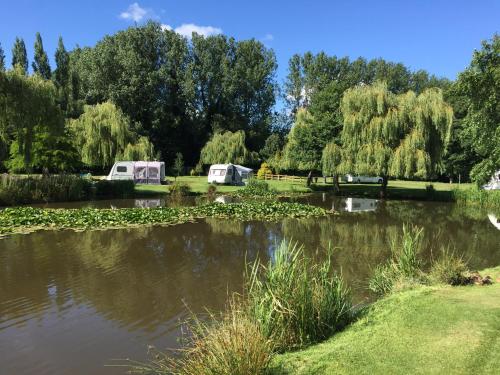 a pond in a park with two tents next to it at Everglades in Denver