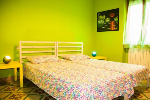 サン・ジュリアーノ・テルメにあるSabry apartmentの緑の壁、ベッド付きのベッドルーム1室