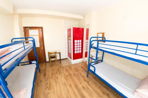 a room with two bunk beds and a red phone booth at Kensal Green Backpackers 2 in London