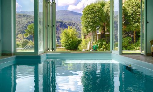an indoor pool with a view of the mountains from a house at B&B Dolce vista al lago Lugano in Porto Ceresio