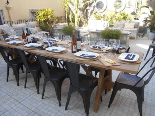 リスボンにあるリスボン ガーデン ブティック ゲストハウスの木製テーブル(椅子付)、ワインボトル、グラス付