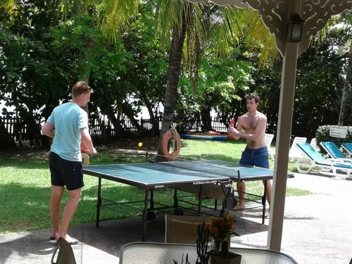 two men playing ping pong on a ping pong table at Plantation Beach Villas in Black Rock
