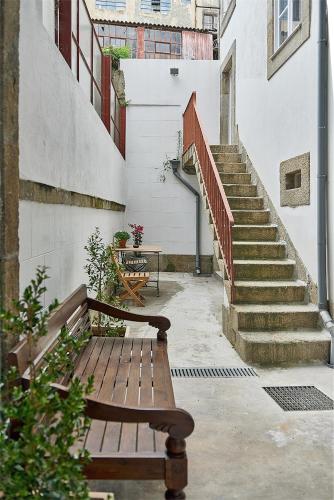 a wooden bench sitting in front of a staircase at PortoSense Almada in Porto