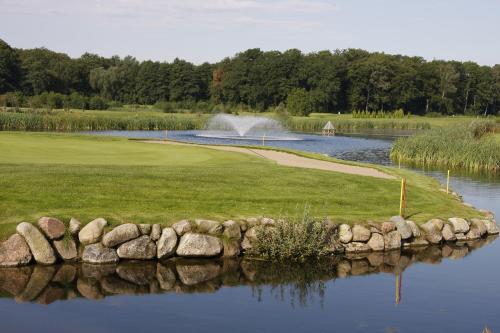a golf course with a pond and a fountain at Golfpark Strelasund in Süderholz