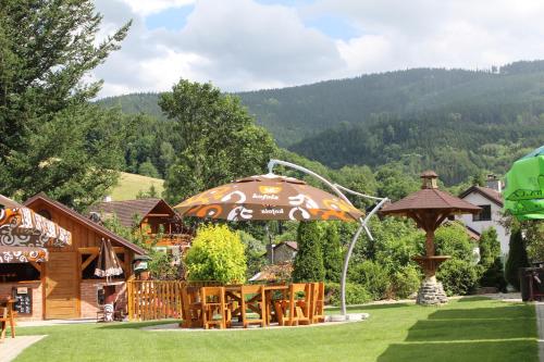 a restaurant with an umbrella and tables in a yard at Hotel STARÝ MLÝN in Jeseník