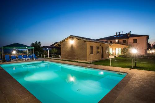a swimming pool in front of a house at night at Agriturismo La Rosa Montefalco in Montefalco