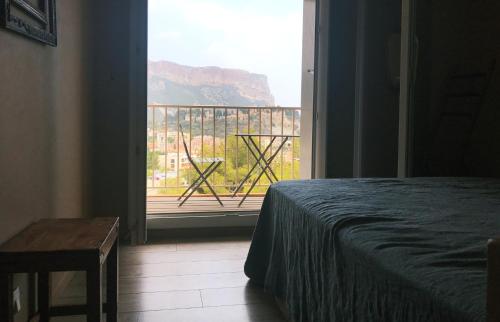une chambre avec un lit et une vue sur un balcon dans l'établissement Le Bosquet, à Cassis