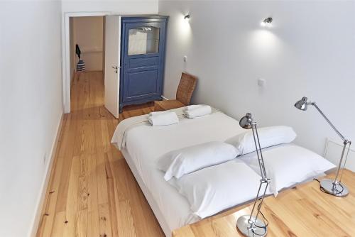 a bedroom with two beds and a blue door at PortoSense Almada in Porto