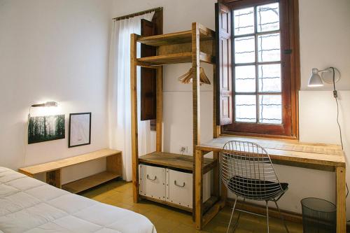 a bedroom with a bed and a chair and a window at Casa Helsinki in Cordoba