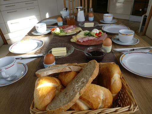 a table with a basket of bread and eggs on it at Privatzimmer Helene Mariacher in Virgen