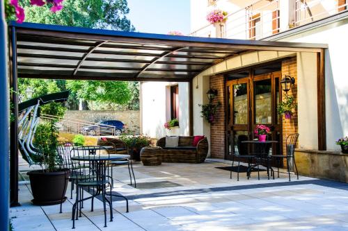 a patio with tables and chairs under a wooden pergola at Hotel Al Ritrovo in Piazza Armerina