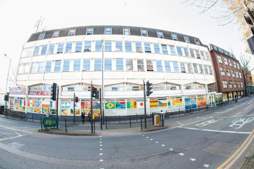 a large white building on the corner of a street at Kensal Green Backpackers 2 in London