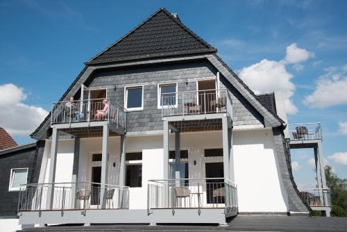 a woman sitting on a balcony of a house at LIONO BoutiqueHotel in Goslar