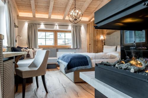 a bedroom with a bed and a fireplace in a room at Aktiv- & Wellnesshotel Bergfried in Tux