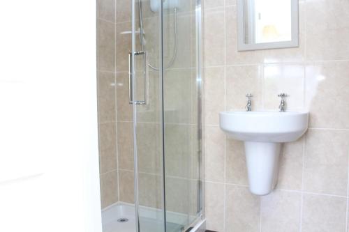 a bathroom with a sink and a glass shower at Laurels Guesthouse in Witney