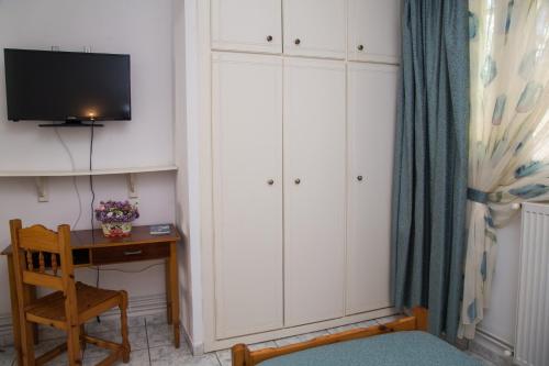 um quarto com uma secretária, uma televisão e um armário em Apartments MARGARITA Kaizer Bridge em Achílleion