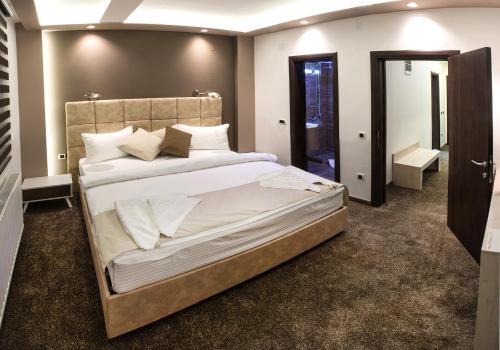 a bedroom with a large bed with white sheets and pillows at Hotel & Restaurant Ponte Bianco in Vranje