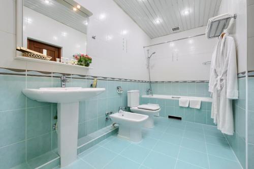 a blue bathroom with a sink and a toilet at Villa Mask in Pyatigorsk
