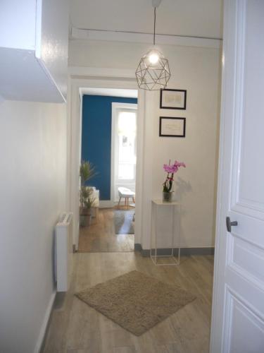 un couloir avec une table et une lampe pendant dans l'établissement au 303, à Lyon