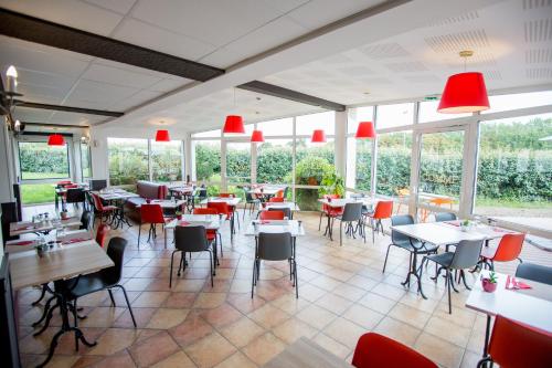 a restaurant with tables and chairs and windows at ibis Cherbourg La Glacerie in Cherbourg en Cotentin