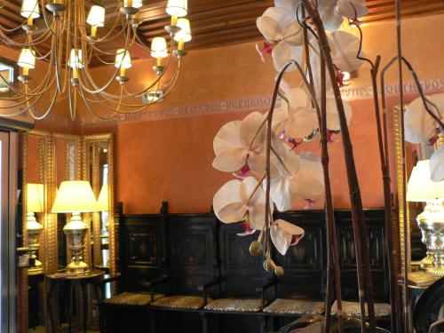 a room with a chandelier and flowers on a table at Posada Real Los Cinco Linajes in Arévalo