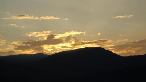 a silhouette of a mountain with a sunset in the background at Chales Recanto das Seriemas in São Roque de Minas