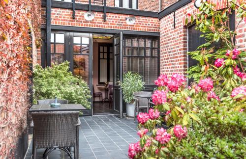 an entrance to a brick building with pink flowers at Main Street Hotel in Ypres