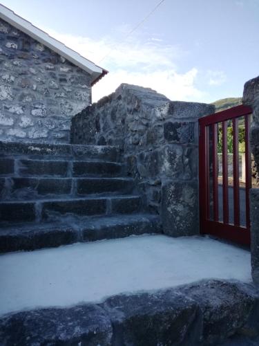 a set of stone stairs with a red door at Melo's Place in Madalena