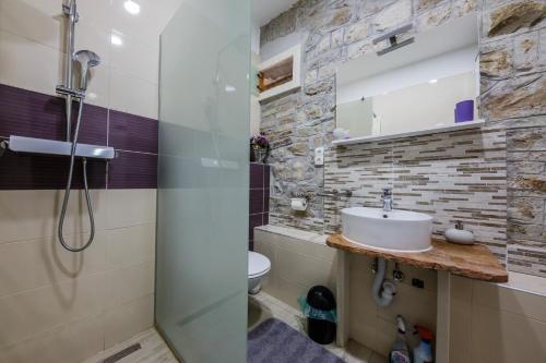 a bathroom with a sink and a shower at Apartman Lavanda in Kaštela