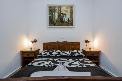 a bedroom with a bed and a painting on the wall at Apartman Lavanda in Kaštela