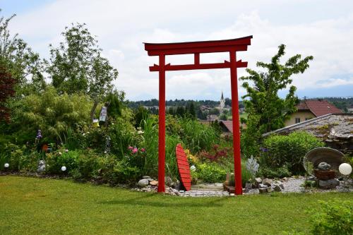 a red torii gate in the middle of a garden at Ferienwohnung Albel in Velden am Wörthersee