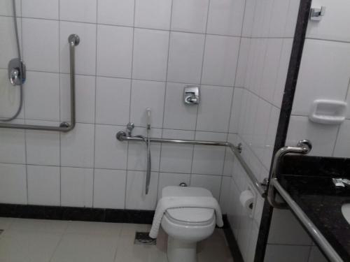 a bathroom with a toilet and a shower stall at Pratti Hotel in Linhares