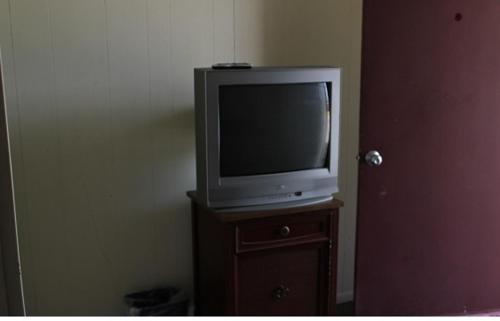 un televisor sentado en la parte superior de un soporte de madera en The Inn, en El Dorado