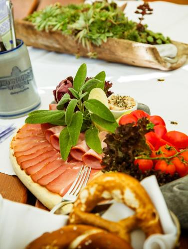 a plate of food with meat and vegetables on a table at Landhotel Schneider in Riedenburg