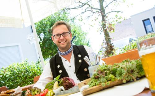 a man sitting at a table with a plate of food at Landhotel Schneider in Riedenburg