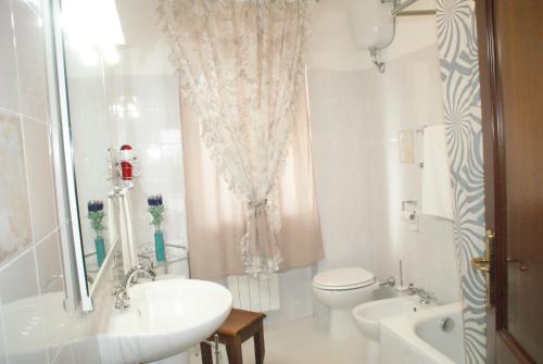 bagno bianco con lavandino e servizi igienici di Bed&Breakfast degli ulivi a Fiano Romano
