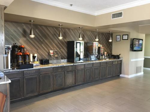 a bar with wooden cabinets in a room at Super 8 by Wyndham Jackson Ridgeland in Jackson