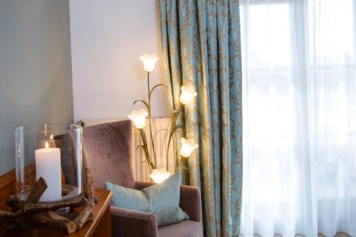 a room with a chair and a mirror and a window at Landhotel Schneider in Riedenburg