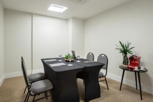 a black table and chairs in a room at Intercity Porto Alegre Cidade Baixa in Porto Alegre