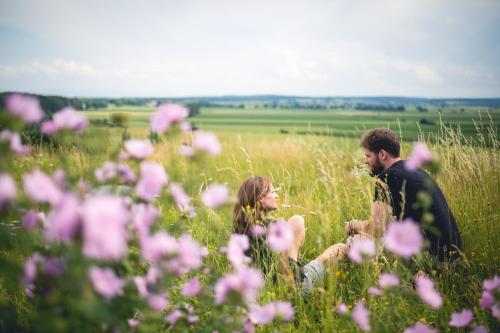 a couple sitting in a field of pink flowers at Hotel Alpenrose in Bad Wörishofen